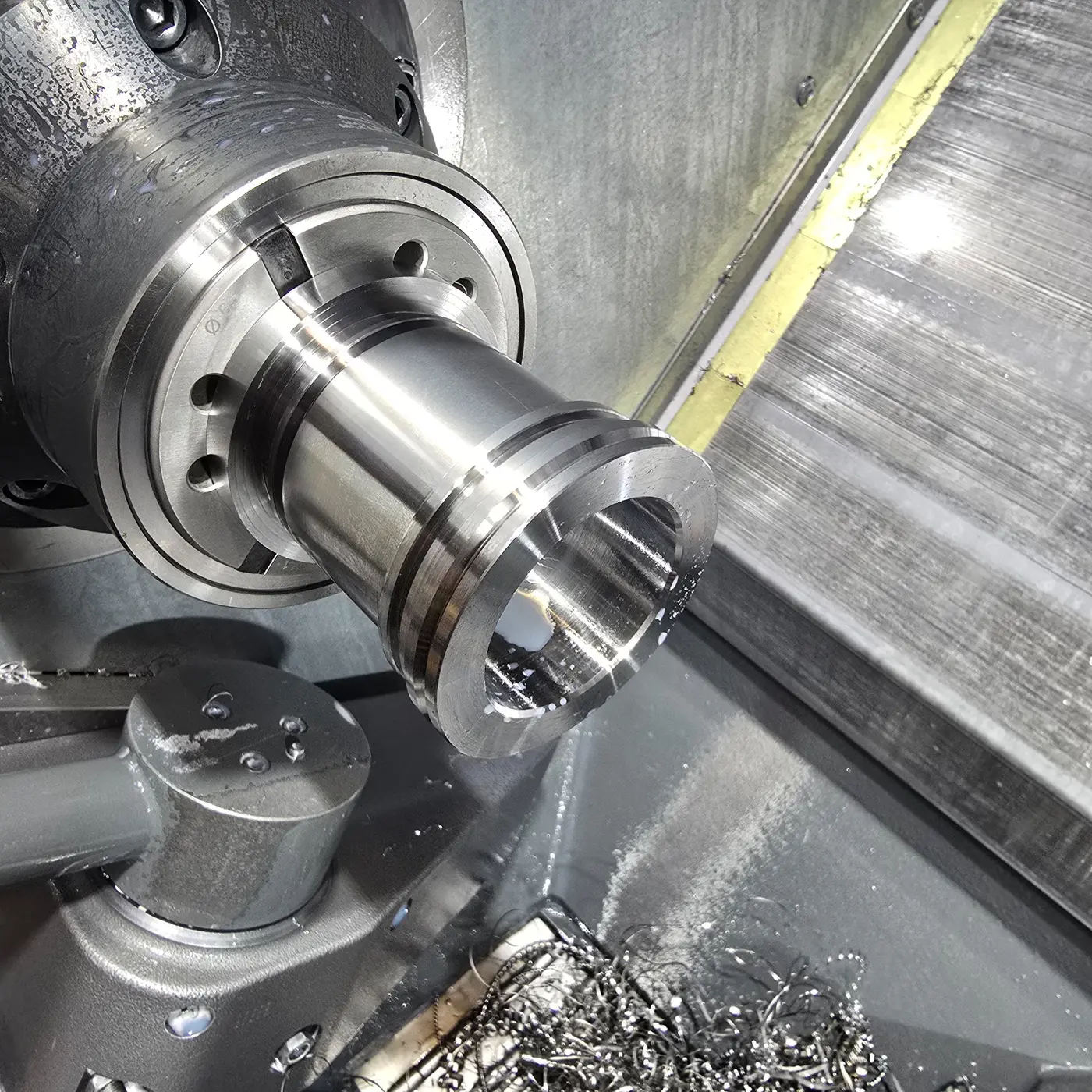 Metal part being machined in a CNC lathe